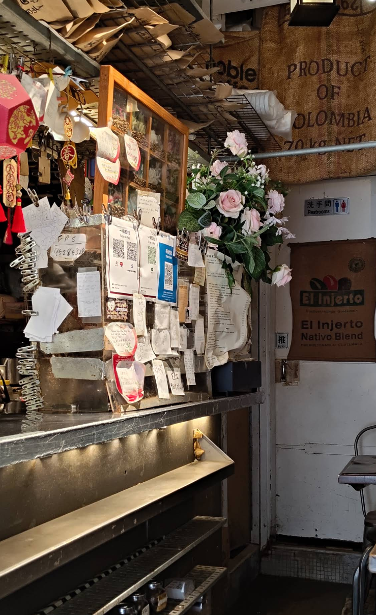 Inside the cafe: shelves hung with bean sacks, hand-written notes and fresh flowers
